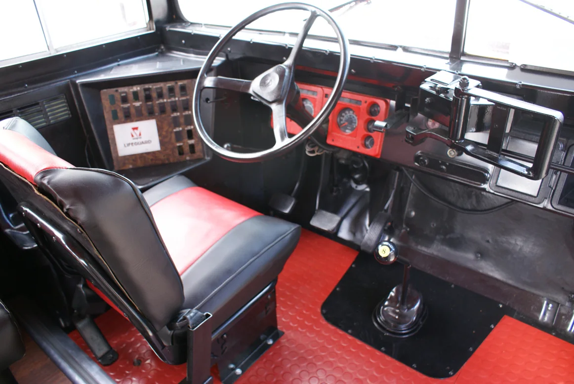 The driver seat re-covered in red and black, with a red diamond-plate floor