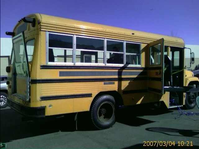 The original yellow Bluebird school bus parked in a lot before the conversion