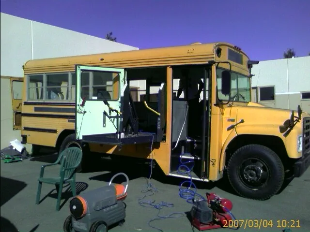 The original yellow Bluebird school bus parked in a lot before the conversion