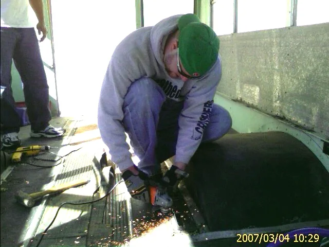 Crew members stripping the old school-bus seats and flooring out of the bus