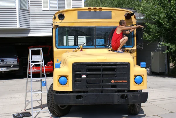 The yellow bus at the house, being sanded and taped for paint