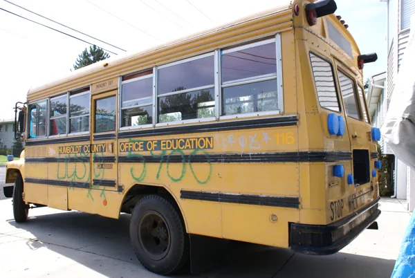 The yellow bus at the house, being sanded and taped for paint
