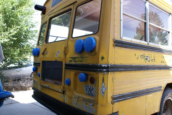 The yellow bus at the house, being sanded and taped for paint