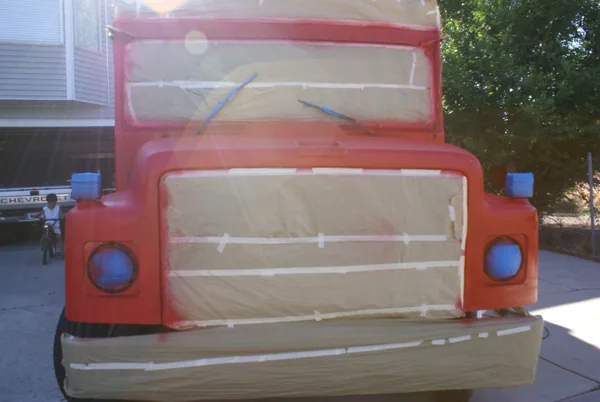 The bus freshly sprayed red with windows and grille still masked