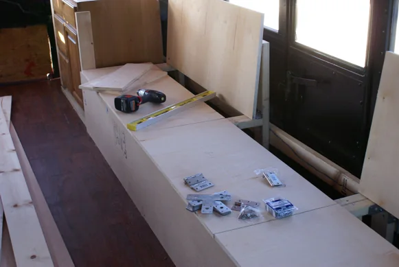 Bench and cabinet frames being built inside the stripped-out bus