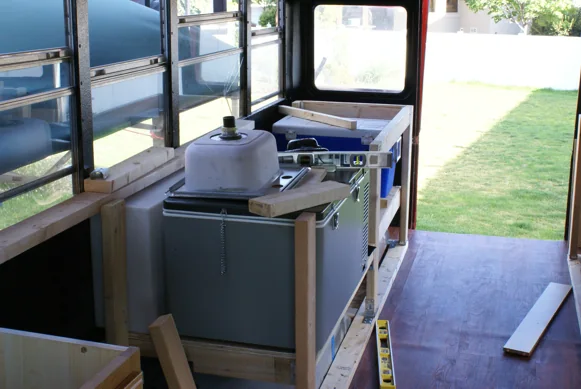Galley framing inside the bus with the fridge, sink and cooler fitted