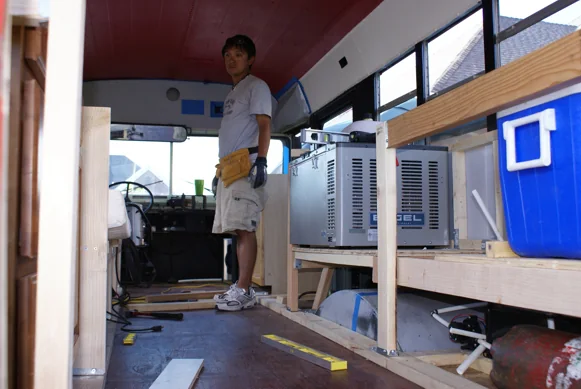 Bench and cabinet frames being built inside the stripped-out bus