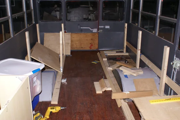 Bench and cabinet frames being built inside the stripped-out bus