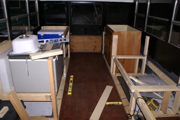 Bench and cabinet frames being built inside the stripped-out bus