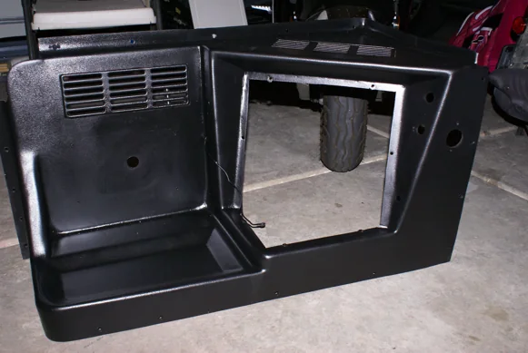 The engine cover, freshly painted black, waiting to go back in