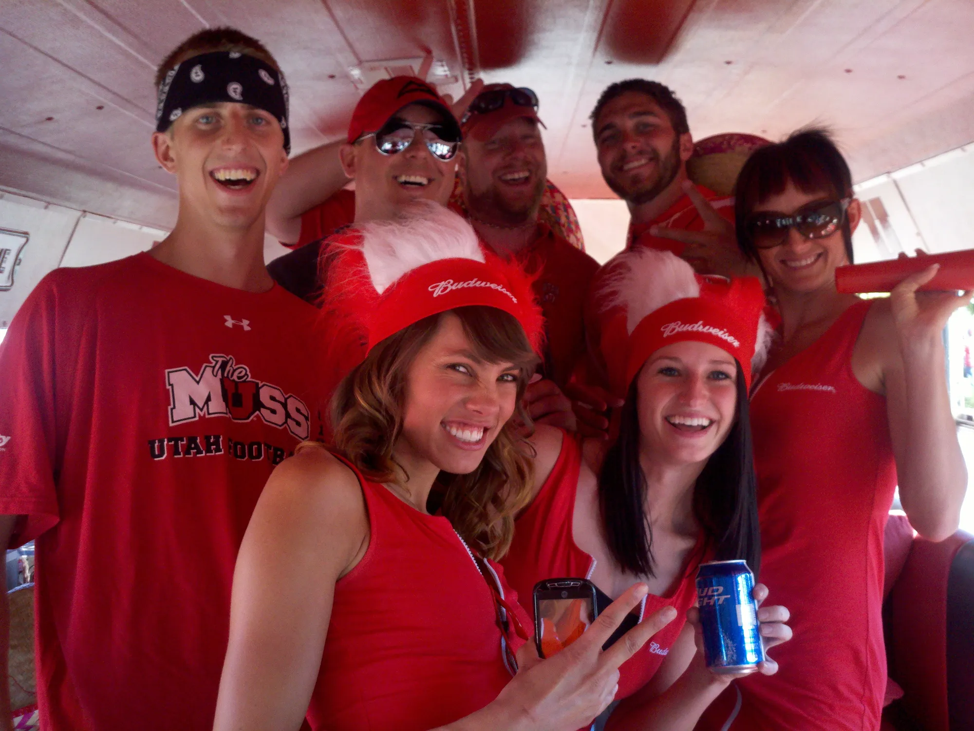Crew and friends in red packed together inside the bus