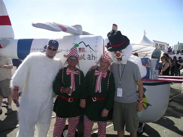 The crew in elf and costume outfits beside their snowy flying machine at Red Bull Flugtag
