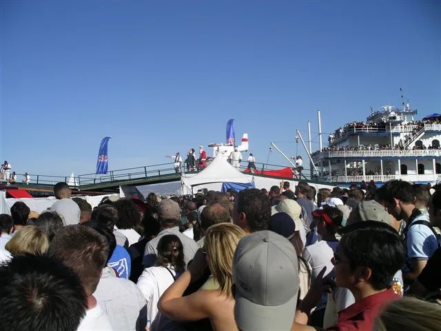 The crowd watching a flying machine launch off the pier into the bay