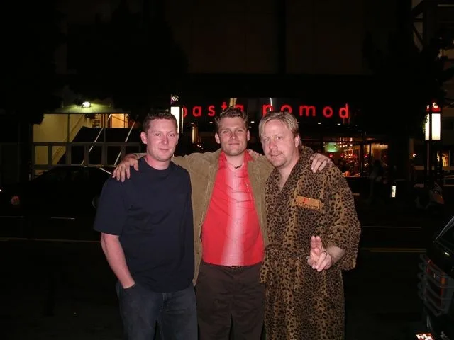 Three friends, one in a leopard robe and one in a red vest, out at night