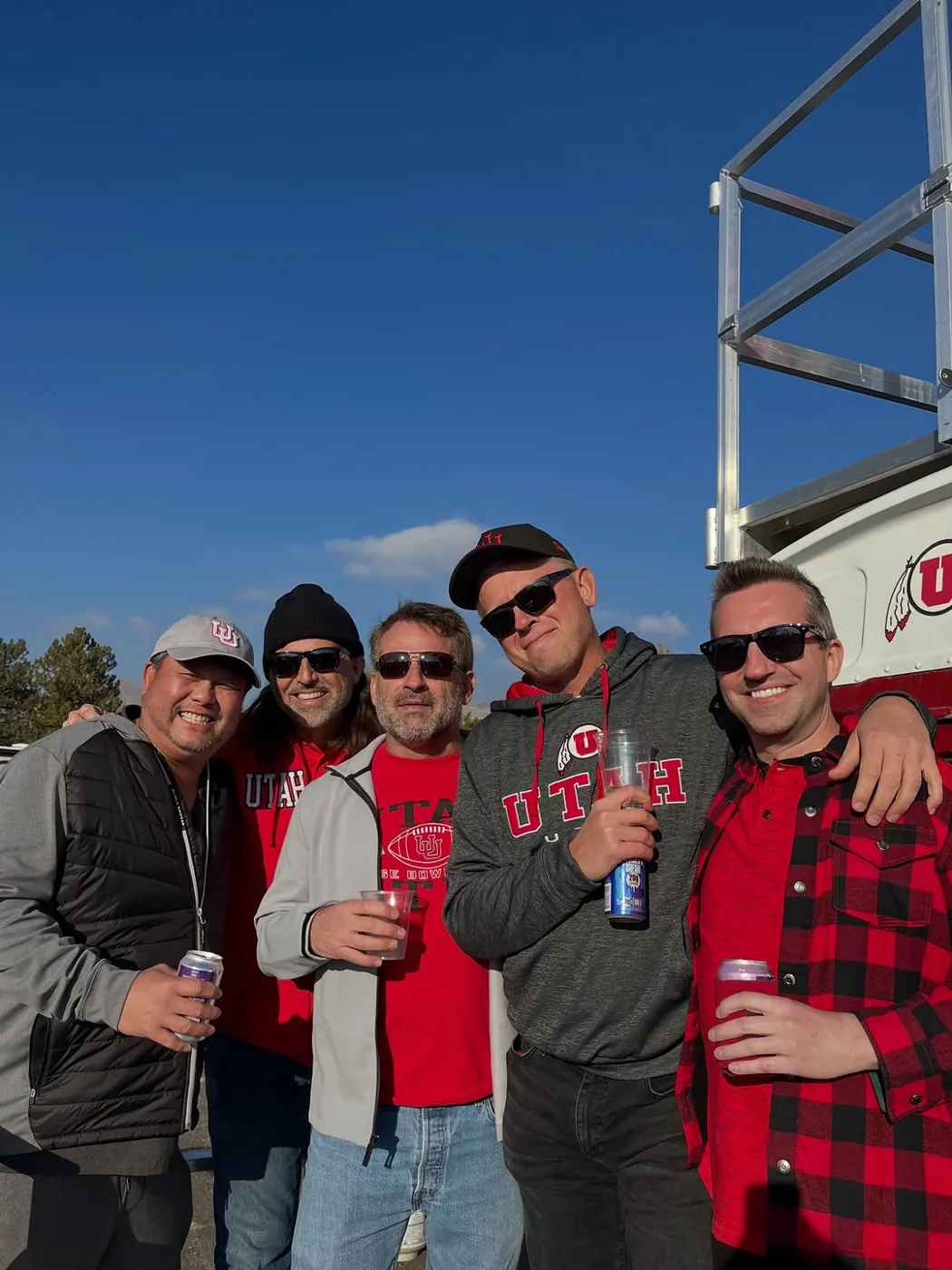 Five friends in Utah gear with drinks in the Guardsman lot