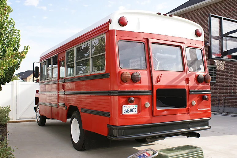 Rear three-quarter view of the bus in its new red paint