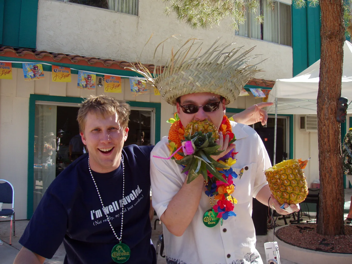 A crew member in a straw hat and leis cheering with a friend on a Parrothead trip