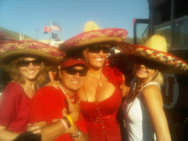 Tailgate guests in costume hats at the Pig Bus