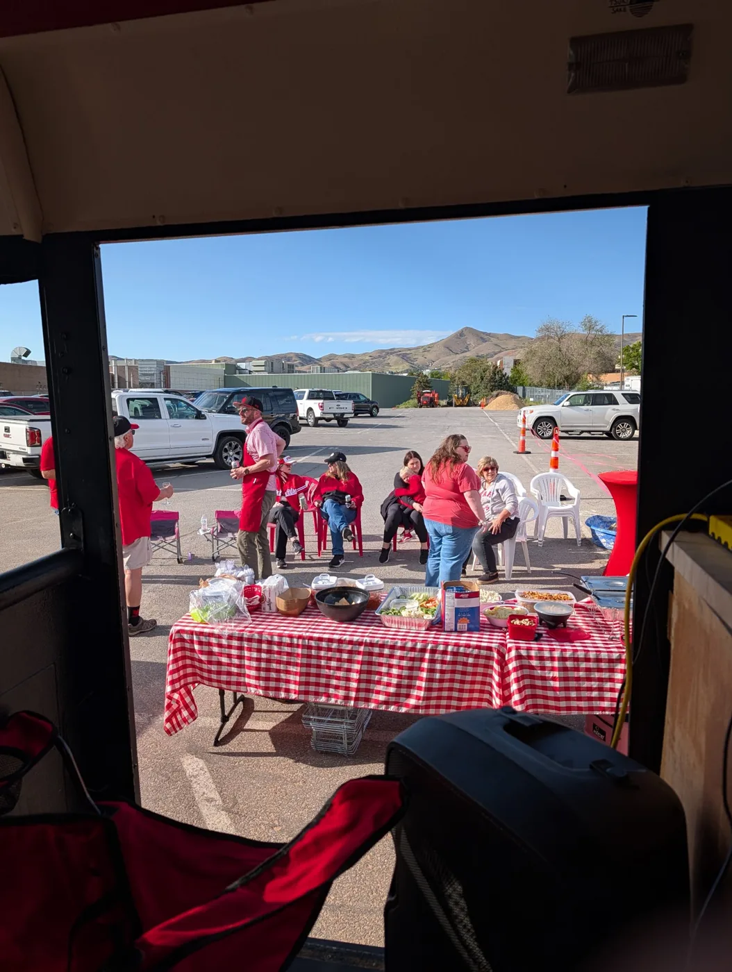 View from Porky’s door of the gingham food table and guests in red chairs