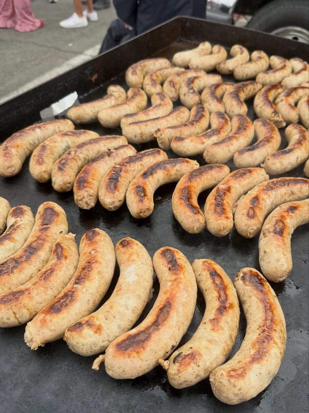 A flat-top covered in browned bratwurst