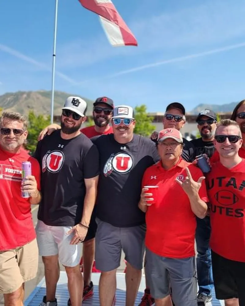A group of crew and friends on the roof deck with a flag overhead