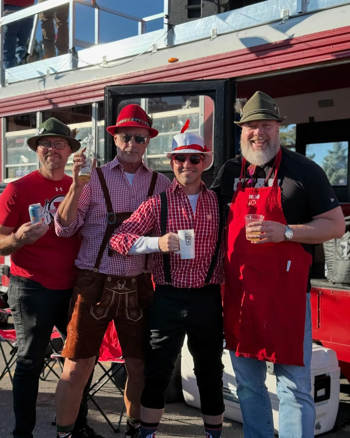 Four crew members in lederhosen and Alpine hats in front of Porky