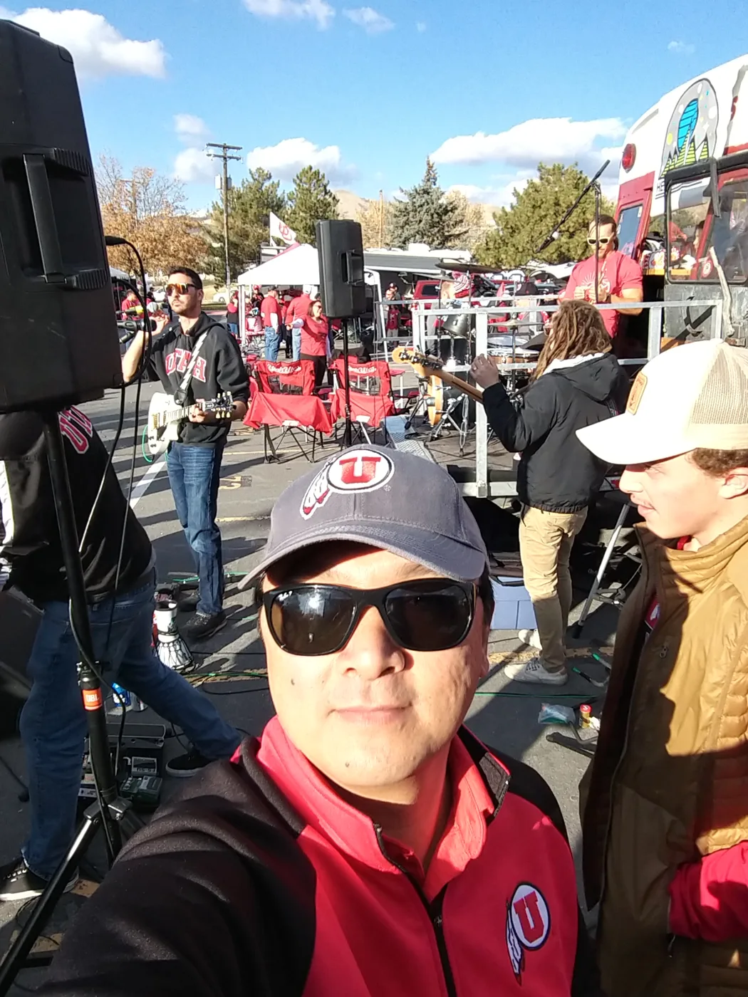 A crew member’s selfie in front of a live band playing beside the bus
