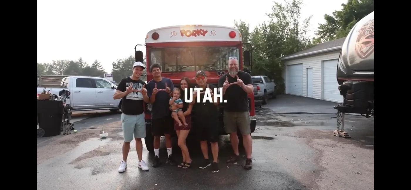 The crew and family throwing the U in front of Porky, with UTAH. across the frame