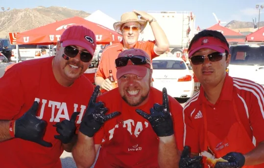 Three crew members in Utah gear at an early tailgate